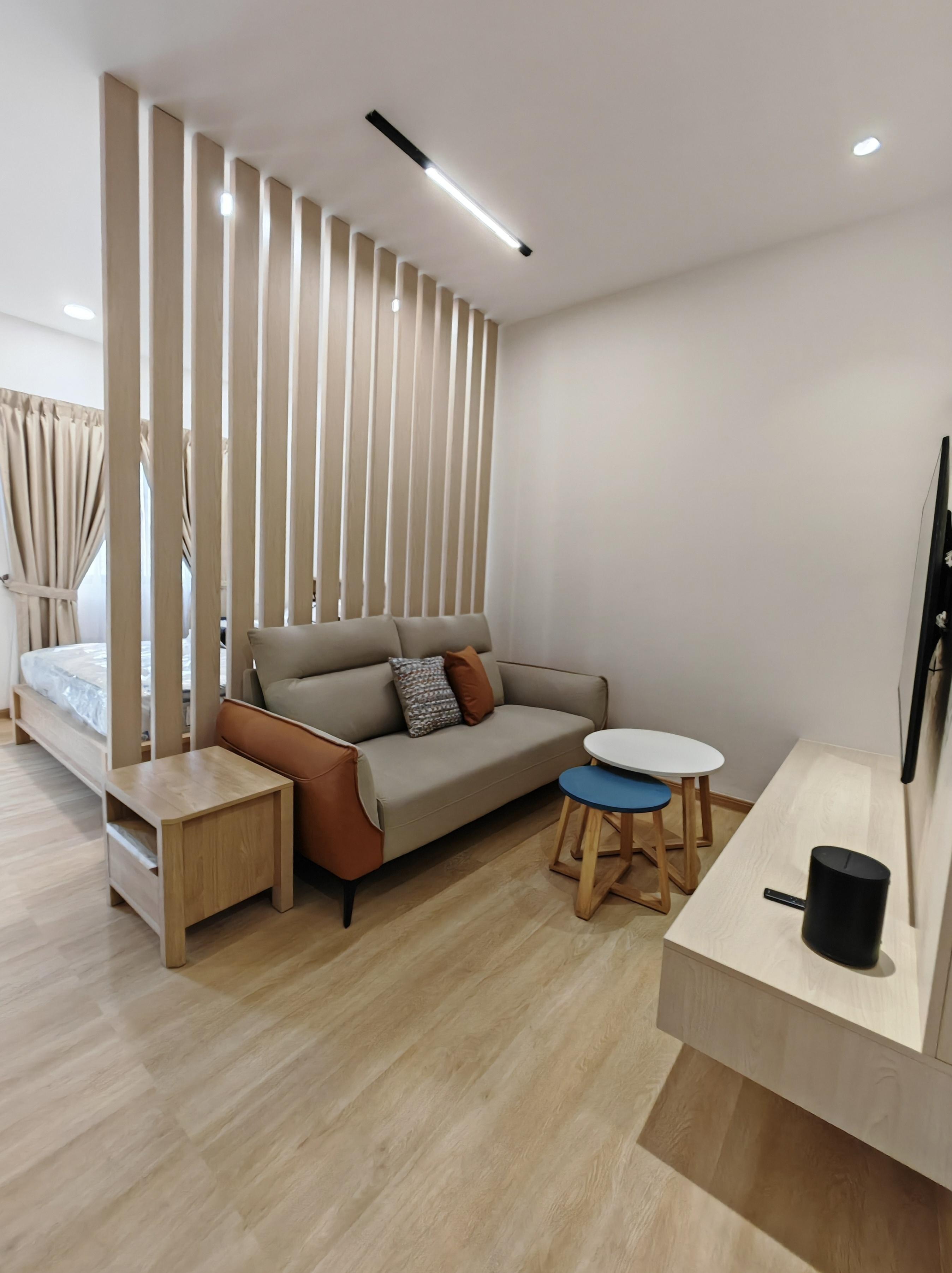 Completed bedroom area showing vertical wood-look slatted partition