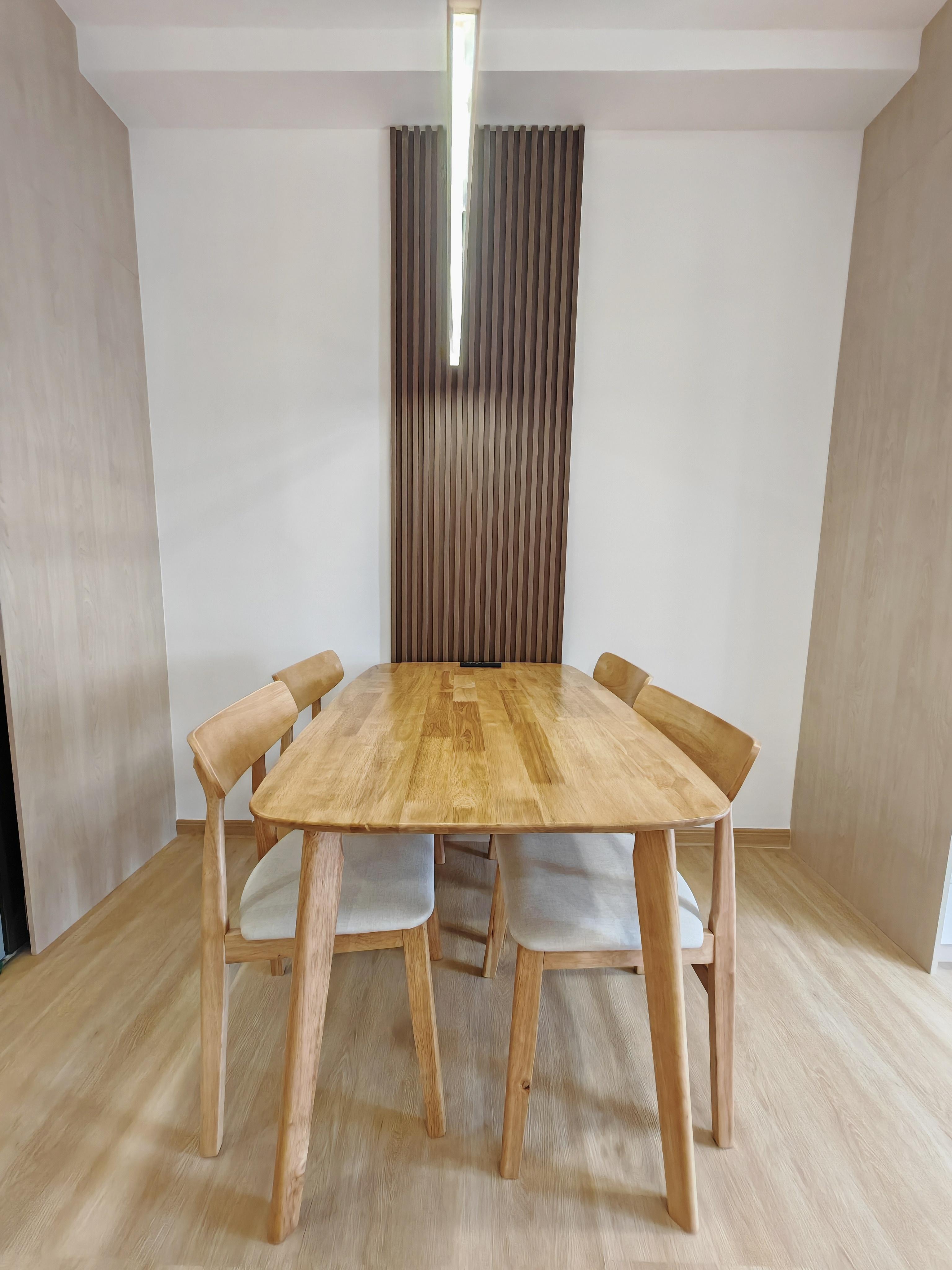 Dining area showing table, upholstered chairs, and fluted vertical accent wall feature