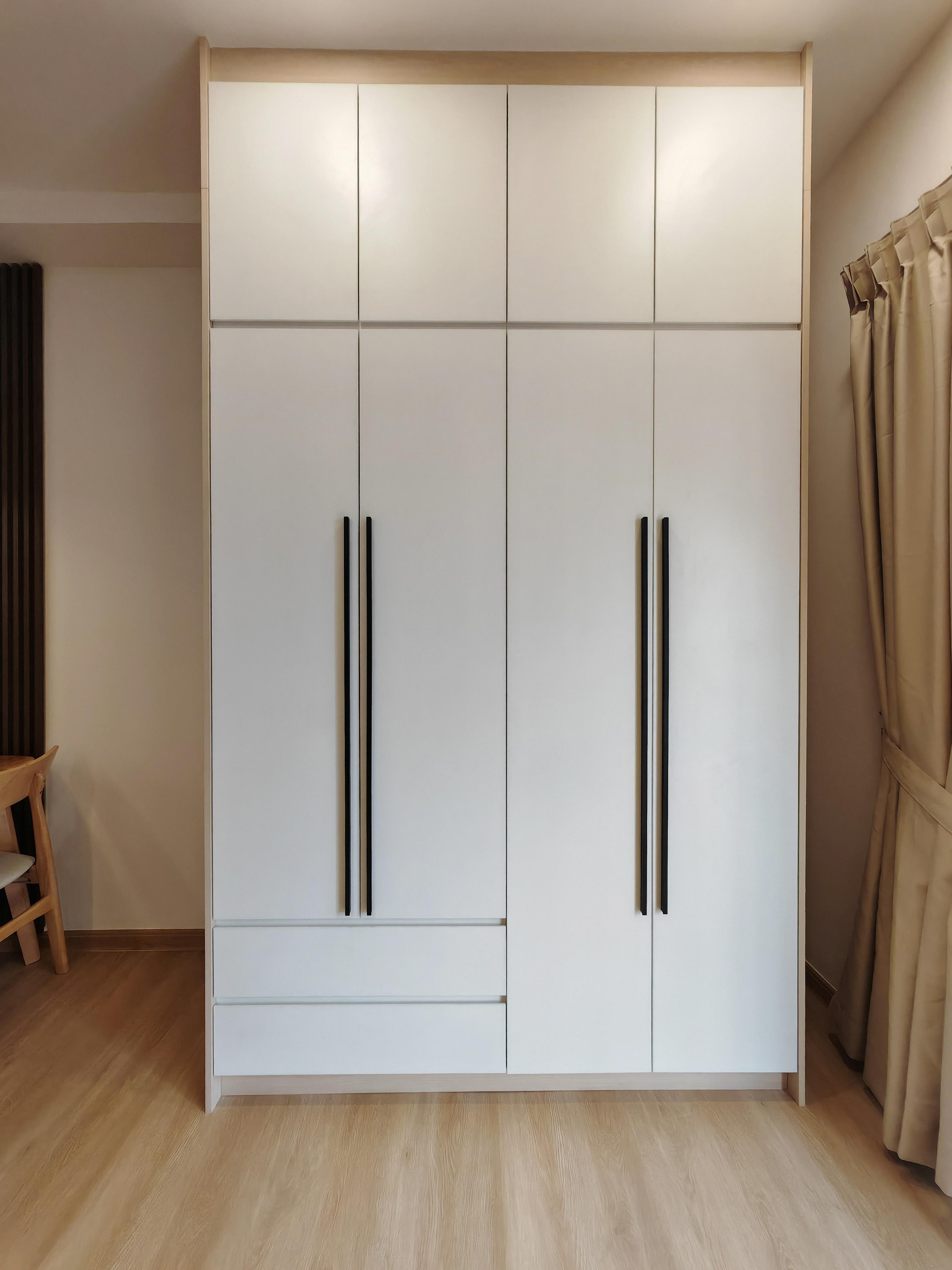 Full-height built-in wardrobe with white door fronts and top overhead storage