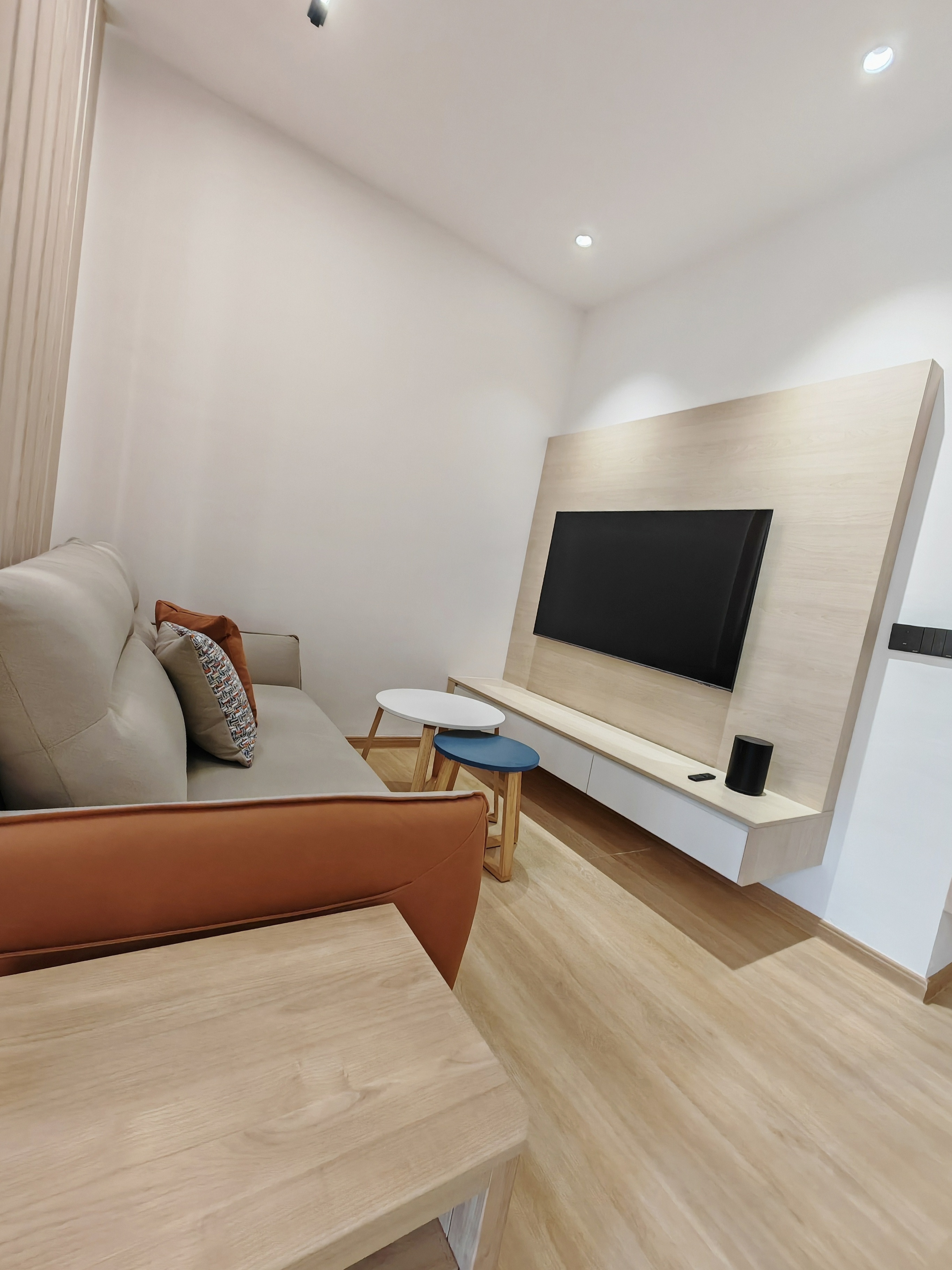 Completed living area showing mounted television against wood-look feature backer board